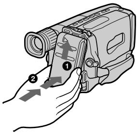 Diagram showing a hand holding a video camera with labeled parts and directional arrows indicating motion or movement.