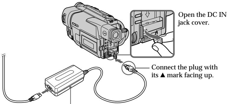 Open the DC IN jack cover. Connect the plug with its ▲ mark facing up.