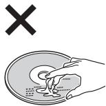 Diagram showing a hand holding a circular object with a cross symbol above it, indicating a warning or rejection.