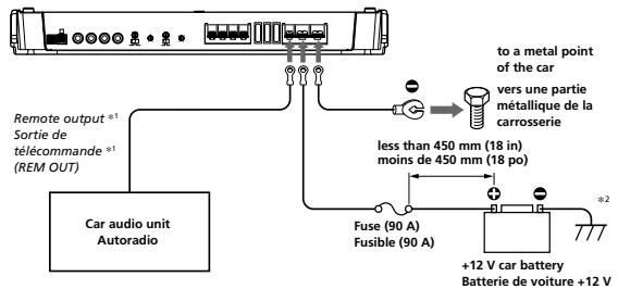 to a metal point of the car vers une partie méralique de la carrosserie less than 450 mm (18 in) moins de 450 mm (18 po) +2 +12 V car battery Batterie de voiture +12 V Remote output *1 Sortie de télécommande *1 (REM OUT) Car audio unit Autoradio Fuse (90 A) Fusible (90 A)