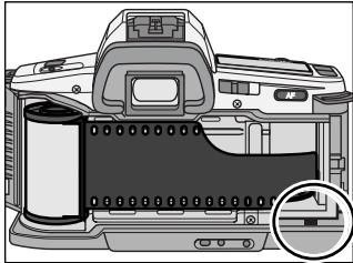MINOLTA DYNAX 3L - Engager l'amorce sur les rails du guide-film et la tirer jusqu'au repère. - 1