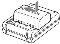 SONY A65 - Inserire la batteria sul caricabatterie. - 1
