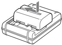SONY A77 - Inserire la batteria sul caricabatterie. - 1