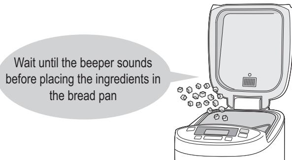 Wait until the beeper sounds before placing the ingredients in the bread pan