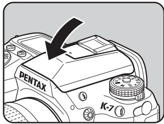 PENTAX K-7 - Appuyez sur la partie indiquée sur l'illustration pour rétracter le flash. - 1