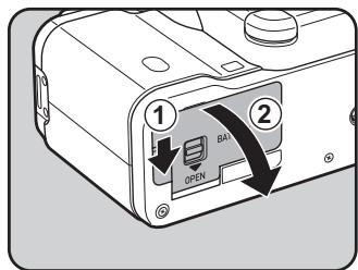 PENTAX K-01 - Poussez l'interrupteur de déverrouillage de la trappe de protection du logement de la batterie vers la position OPEN (①) pour déverrouiller. - 1