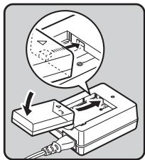 PENTAX K70 - Orientez le repere  de la batterie vers le haut et inserez la batterie dans le chargeur. - 1