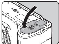 PENTAX K70 - Ouvrez la trappe de protection du logement de la batterie. - 3