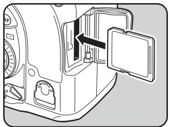 PENTAX K20D - Introduisez la carte à fond, l'étiquette de la carte mémoire SD étant dirigée vers l'écran. - 1