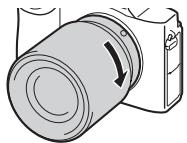 SONY ALPHA 7 - Drehen Sie das Objektiv im Uhrzeigersinn, während Sie es leicht gegen die Kamera drucken, bis es in der Verriegelungsposition einrastet. - 1