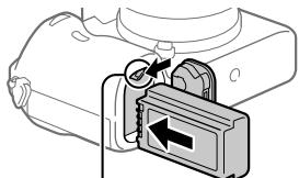SONY ALPHA 6400 - Indsæt batteriet, mens du trykker på lase mekanismen med spidsen af batteriet, indtil batteriet lases på plads. - 1