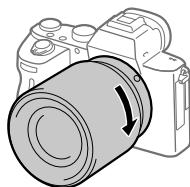 SONY ALPHA A7 III - Злегка притискаючи об'єктив до фотоапарата, поверніть об'єктив у напрямку стрілки, доки він не клацне у зафіксованому положенні. - 1