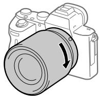 SONY ALPHA A7 III - Аккуратно задвигая объектив в камеру, поворачивайте его медленно в направлении стрелки до тех пор, пока он не защелкнется в фиксированном положении. - 1