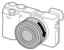 SONY A6500 - Enquanto empurra a objetiva ligeiramente em direção da-camera, rode a objetiva lentamente na direção da seta até fazer clique na posicao bloqueada. - 1