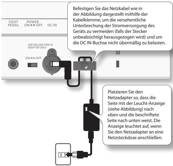FOOT PEDAL POWER ON OFF DC IN USE ROLAND PSB-1U ADAPTOR ONLY ON OFF Befestigen Sie das Netzkabel wie in der Abbildung dargestellt mithilfe der Kabelklemme, um die versehentliche Unterbrechung der Stromversorgung des Geräts zu vermeiden (falls der Stecker unbeabsichtigt herausgezogen wird) und um die DC IN-Buchse nicht übermäßig zu belasten. Platzieren Sie den Netzadapter so, dass die Seite mit der Leucht-Anzeige (siehe Abbildung) nach oben und die beschriftete Seite nach unten weist. Die Anzeige leuchtet auf, wenn Sie den Netzadapter an eine Netzsteckdose anschließen.