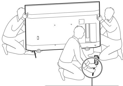SONY XH90 - Remove one side of the Table-Top Stand at a time. Firmly hold the Table-Top Stand securely with both hands while the other people lift up the TV. - 1