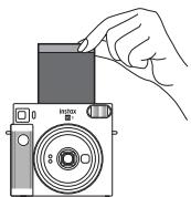 FUJIFILM INSTAX SQ1 CHALK WHITE - Quand le son du film en cours d'éjection s'arrête, tenez le film éjecté par le côte et retirez-le. - 1
