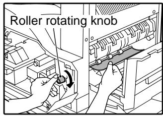 SAGEM MF 9323/ MF 9327 - Carefully remove the misfed paper. Turn the roller rotating knob in the direction of the arrow to assist in removing it. - 1