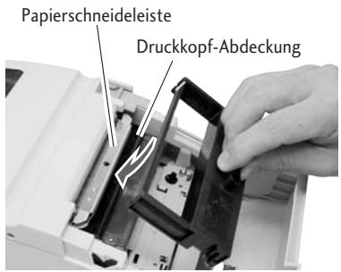 CITIZEN CD-S500 - Führren Sie die Kassette in den Drucker ein, bis ein Klicken zu horen ist. In dieser Position befindet sich das Farbband zwischen der Papierschneidleiste und der Abdeckung des Druckkopfs. Wenn es schwierig ist, die Kassette einzufahren, dann drehen Sie den an der Kassette befindlichen Knopf erneut. - 1