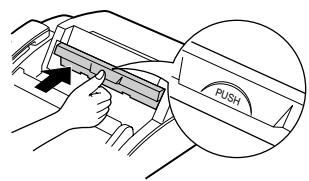Diagram showing hand positioning a mechanical component with an 'PUSH' label, likely illustrating a push button or motion instruction.