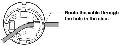 Route the cable through the hole in the side.