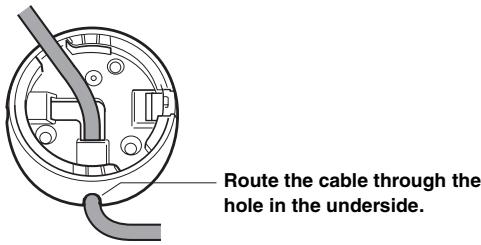 Route the cable through the hole in the underside.