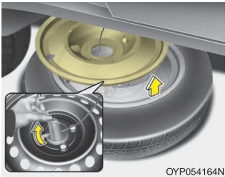 KIA Sedona YP (2014-2018) - Enlever le pneu de secours - 3