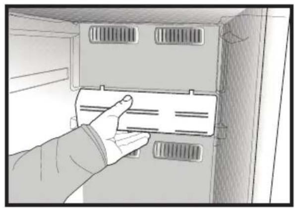 Hand placing a labeled panel into a cabinet with ventilation grilles (no text or symbols visible)