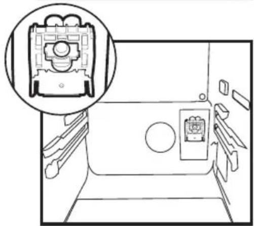Interior view of a vehicle showing a mounted device with a circular head and internal compartments (no text or symbols visible)