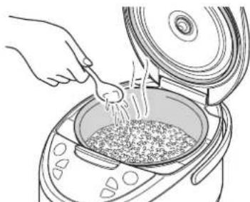 Tiger JAXT10U - Ajoutez 1 à 2 cuillères à soupe d'eau uniformément sur le riz. - 1