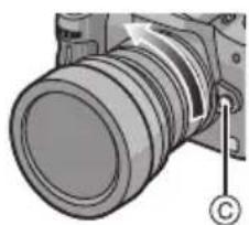 PANASONIC Lumix G 714mm f4 - Halten Sie die Objektiventriegelung gedrückt © und drehen Sie das Objektiv so weit wie möglich in Pfeilrichtung, bis Sie es abnehmen können. - 1