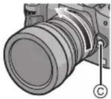 PANASONIC Lumix G 714mm f4 - Premere il pulsante di sblocco dell'obiettivo © e nel contempo ruotare fino in fondo l'obiettivo nella direzione indicata dalla freccia per rimuoverlo. - 1