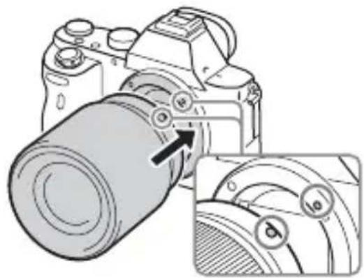 SONY Alpha ILCE7M2K - Monte a objetiva alinhando as marcas brancas de indexação (índices de montagem) na objetiva e na câmara. - 1