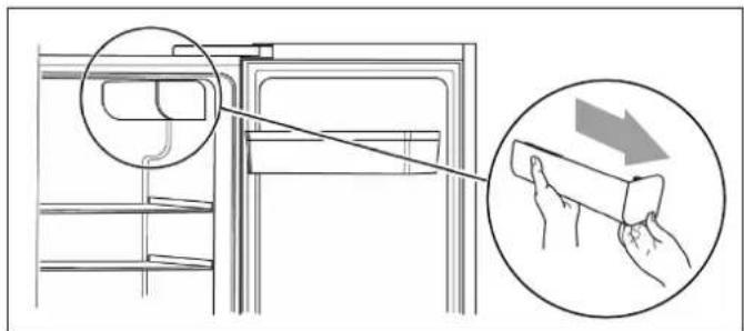 Diagram showing a refrigerator interior with a hand holding a rectangular object, annotated with an arrow indicating cleaning or repair process.