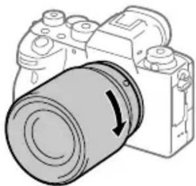 SONY Alpha A9 II - While pushing the lens lightly toward the camera, turn the lens slowly in the direction of the arrow until it clicks into the locked position. - 1
