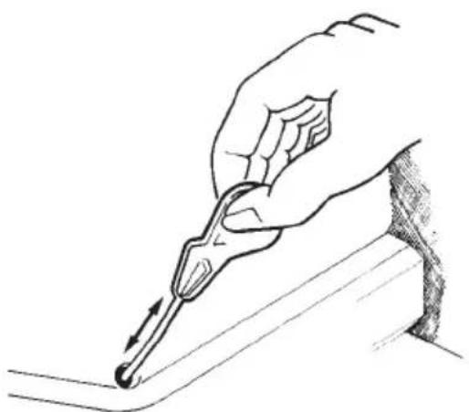 Hand holding a pen writing on a surface, no text or symbols present
