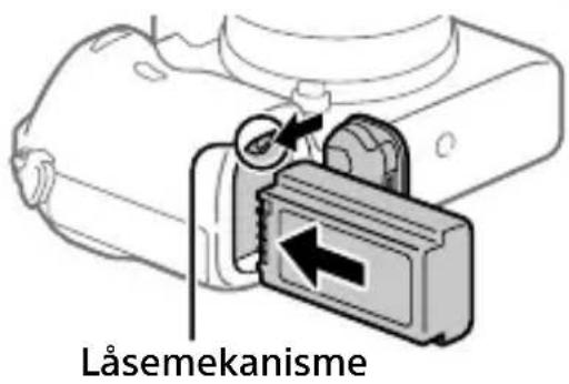 SONY ILCE7M3K - Indsæt batteriet, mens du trykker på låsemekanismen med spidsen af batteriet, indtil batteriet låses på plads. - 1