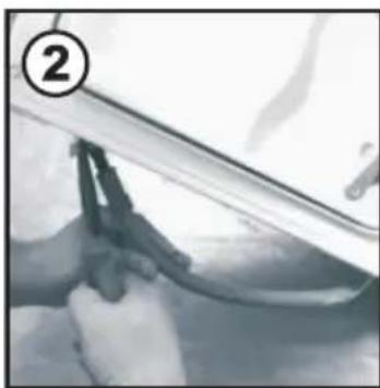 Close-up of hands cleaning a car window with a tool (no visible text or symbols).