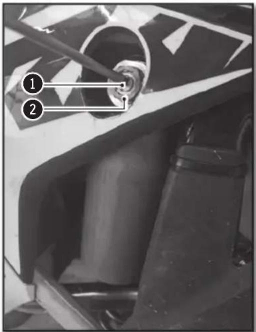 Black-and-white photo of a vehicle's seatbelt mechanism with numbered labels pointing to specific parts.