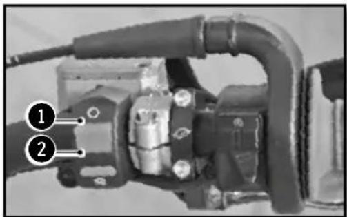 Close-up mechanical component with numbered annotations pointing to parts 1 and 2