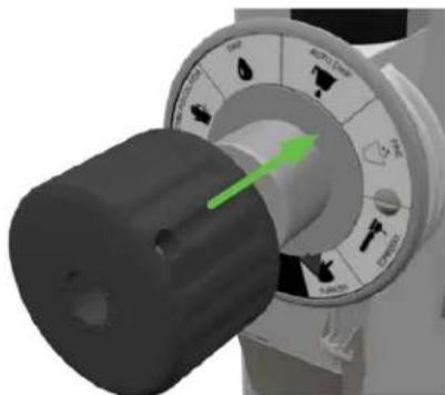 Close-up of a mechanical rotary dial with a green arrow pointing to the knob (no visible text or symbols)
