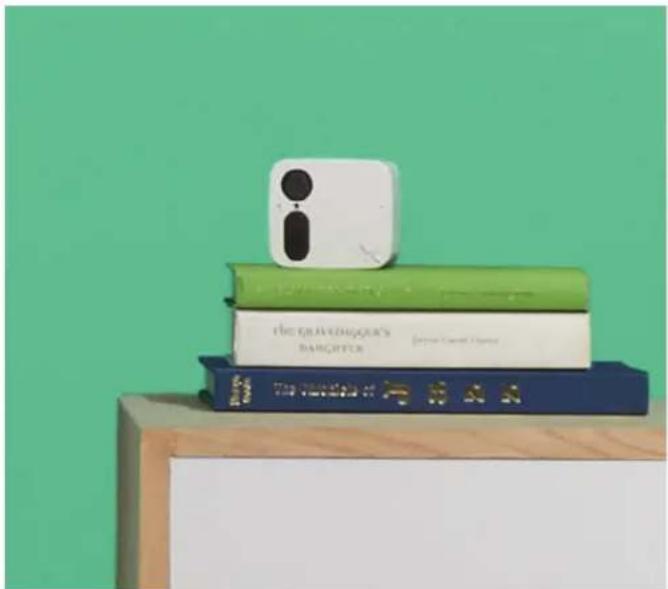 Stack of three books on a wooden stand against a green background (no visible text or symbols)