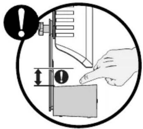 Diagram illustrating a hand pressing a component with warning symbol and measurement arrows, likely indicating a process or safety instruction.
