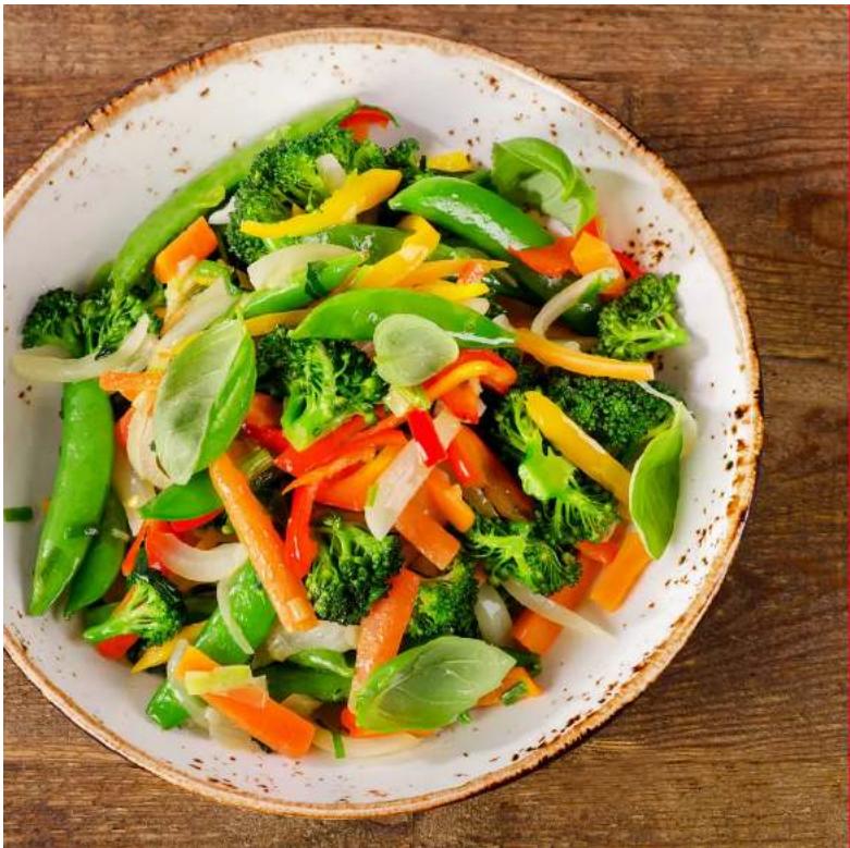 A bowl of stir-fried vegetables including broccoli, carrots, and peppers on a wooden surface (no text or symbols visible)