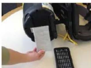 Hand holding a printed document with a calculator nearby, likely for scanning or viewing instructions