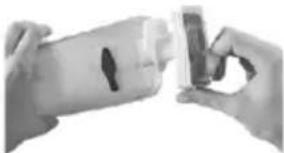 Close-up of hands holding a small object with a dark hole, possibly a device or tool (no visible text or symbols)
