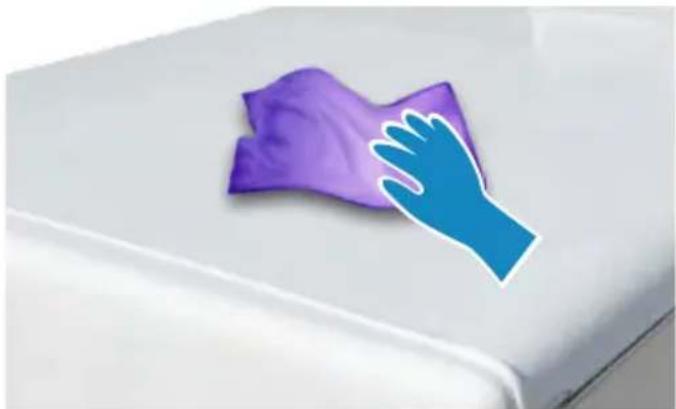 Purple cloth cleaning a white surface with a blue hand partially visible (no text or symbols)
