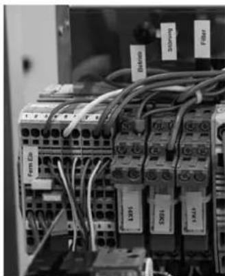 Close-up of an electrical control panel with visible wiring and labeled components (no readable text or symbols beyond labels)