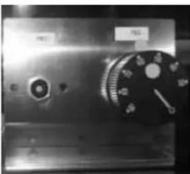 Close-up of a metallic industrial control panel with no visible text or symbols