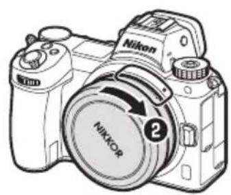 NIKON NIKKOR Z 26mm f2.8 - Maintenez appuyée la commande de déverrouillage de l'objectif (1) tout en tournant l'objet dans le sens indiqué (2). - 2